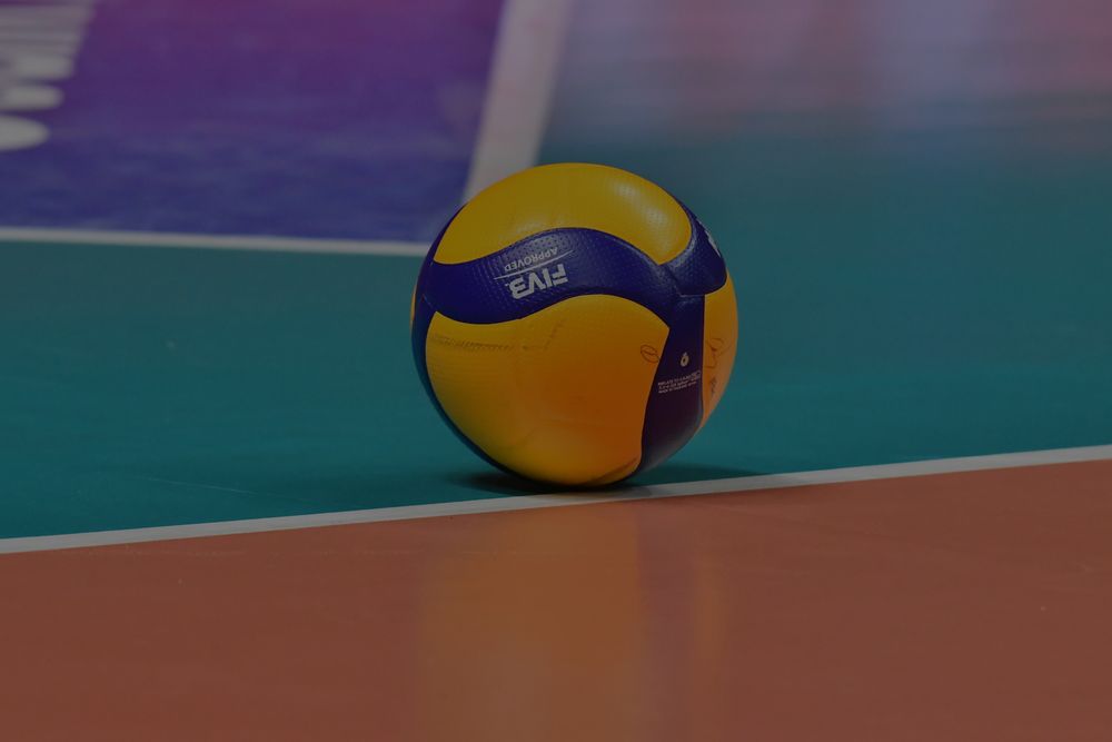 A mikasa volleyball on the ground of an olympic volleyball court